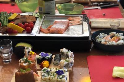 Atelier culinaire avec préparation de sushis et makis, ingrédients frais et ustensiles disposés sur une table.