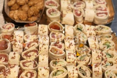 Personnes préparant des sushis autour d'une table avec des bols, ingrédients et ustensiles de cuisine.