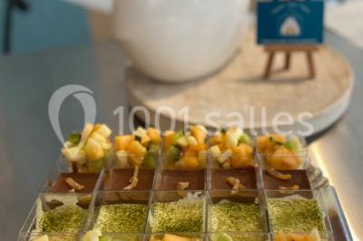 Personnes préparant des sushis autour d'une table avec des bols, ingrédients et ustensiles de cuisine.