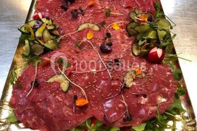 Personnes préparant des sushis autour d'une table avec des bols, ingrédients et ustensiles de cuisine.