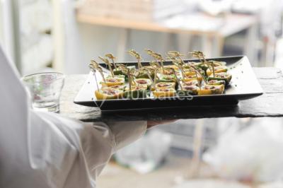 Grand bâtiment classique entouré d'une pelouse bien entretenue, avec un arbre imposant et un petit bassin au premier plan.