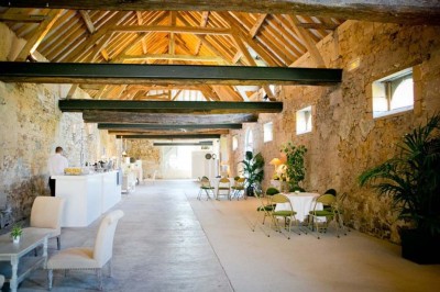 Grand bâtiment classique entouré d'une pelouse bien entretenue, avec un arbre imposant et un petit bassin au premier plan.