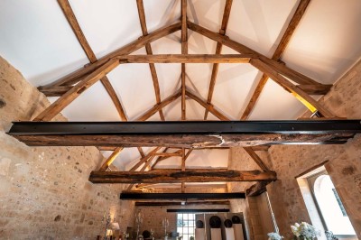 Grand bâtiment classique entouré d'une pelouse bien entretenue, avec un arbre imposant et un petit bassin au premier plan.