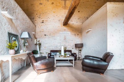 Grand bâtiment classique entouré d'une pelouse bien entretenue, avec un arbre imposant et un petit bassin au premier plan.