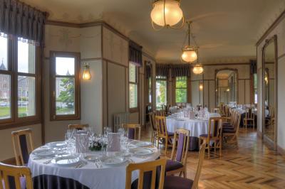 Table élégamment dressée avec vaisselle à motifs bleus, bouquet de fleurs au centre, dans une salle lumineuse et raffinée.