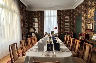 Salle voûtée décorée avec des tables rondes dressées pour un événement, éclairée par des lumières violettes.