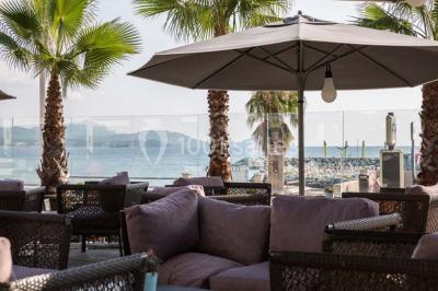Chambre lumineuse avec lit double, papier peint à motifs de flamants roses, mobilier moderne et télévision murale.