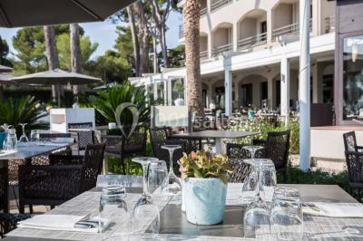 Chambre lumineuse avec lit double, papier peint à motifs de flamants roses, mobilier moderne et télévision murale.