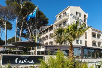 Chambre lumineuse avec lit double, papier peint à motifs de flamants roses, mobilier moderne et télévision murale.