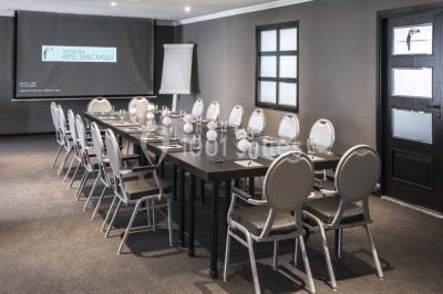 Chambre lumineuse avec lit double, papier peint à motifs de flamants roses, mobilier moderne et télévision murale.