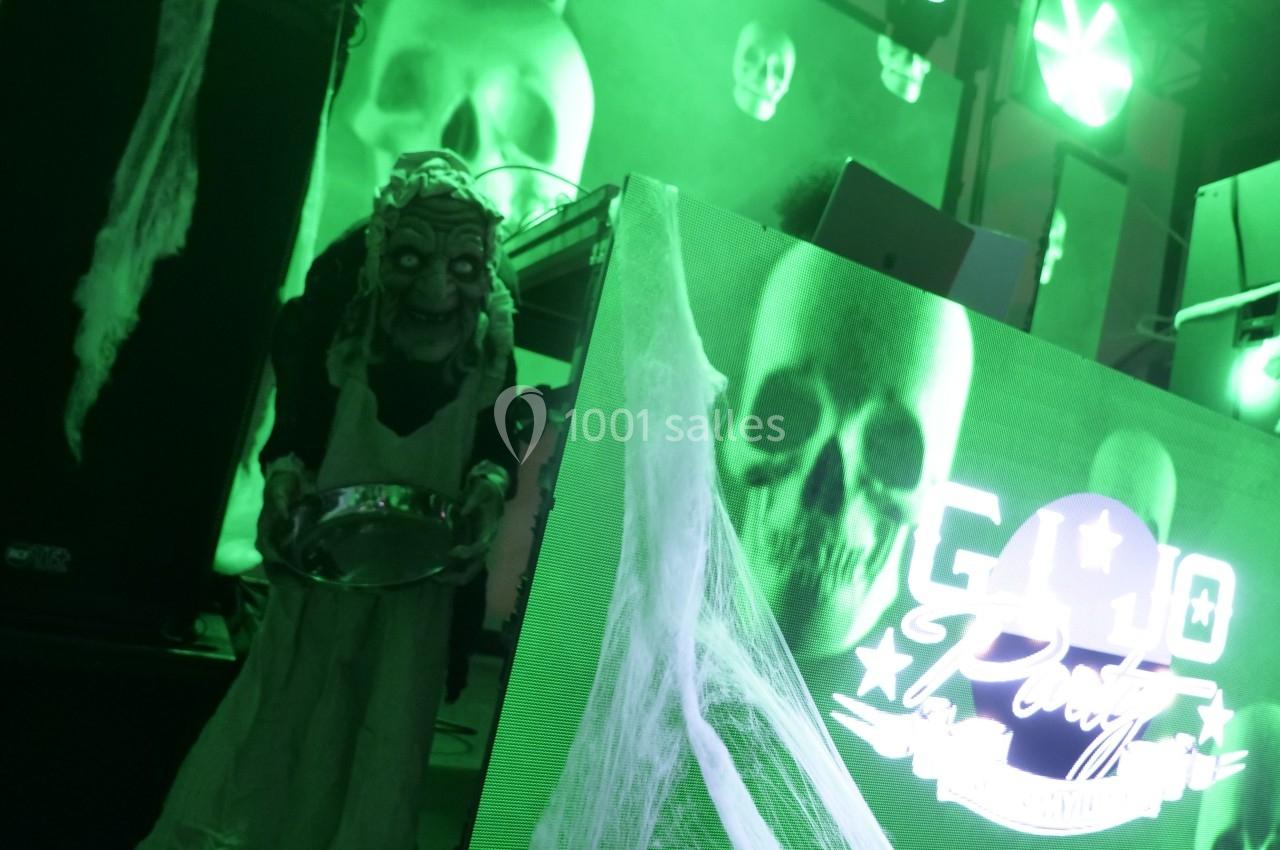 Effets lumineux verts avec décorations d'Halloween, incluant un mannequin effrayant et des toiles d'araignée.