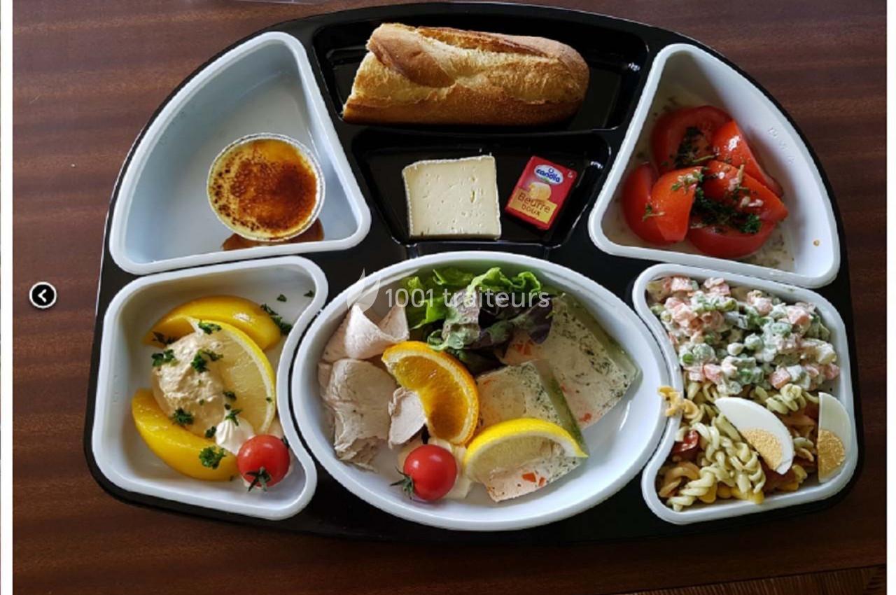 Plateau-repas avec crudités, charcuterie, salade de pâtes, fromage, crème brûlée, fruits et pain.