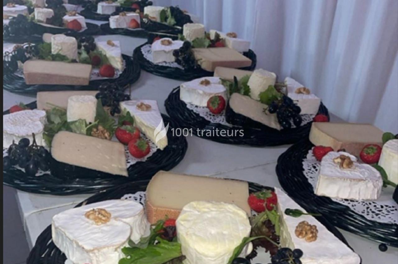 Plateaux de fromages variés avec raisins, fraises, noix et salade, disposés sur des nappes blanches.