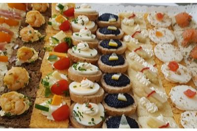 Plateau de canapés variés avec garnitures colorées, incluant crevettes, fromage, légumes, œufs de poisson et herbes.
