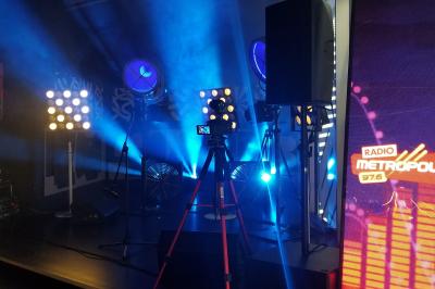 Un bus stationné de nuit devant un bâtiment illuminé, avec des passants en arrière-plan.