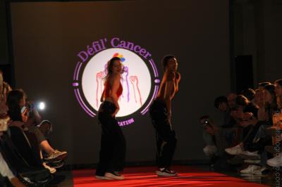 Un bus stationné de nuit devant un bâtiment illuminé, avec des passants en arrière-plan.