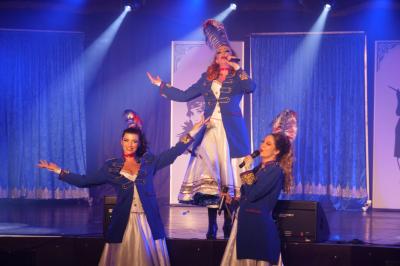 Un bus stationné de nuit devant un bâtiment illuminé, avec des passants en arrière-plan.