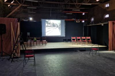 Un bus stationné de nuit devant un bâtiment illuminé, avec des passants en arrière-plan.
