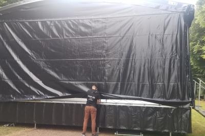 Un bus stationné de nuit devant un bâtiment illuminé, avec des passants en arrière-plan.