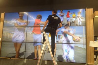 Un bus stationné de nuit devant un bâtiment illuminé, avec des passants en arrière-plan.