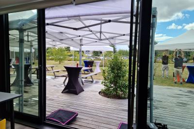 Un bus stationné de nuit devant un bâtiment illuminé, avec des passants en arrière-plan.