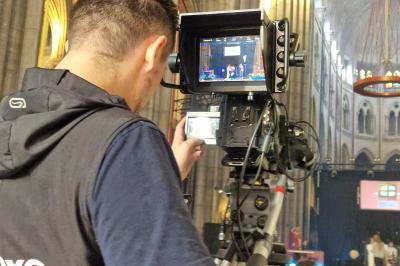 Un bus stationné de nuit devant un bâtiment illuminé, avec des passants en arrière-plan.