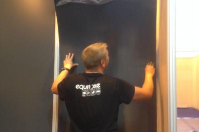 Un bus stationné de nuit devant un bâtiment illuminé, avec des passants en arrière-plan.