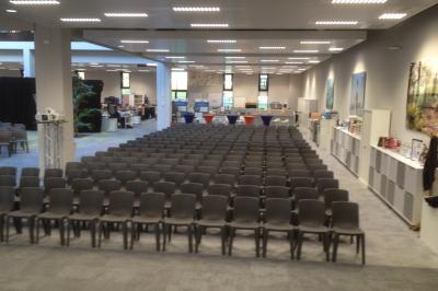 Un bus stationné de nuit devant un bâtiment illuminé, avec des passants en arrière-plan.