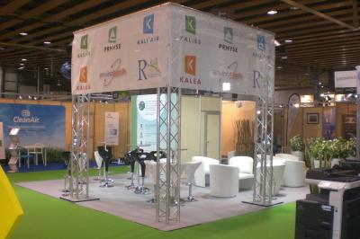 Un bus stationné de nuit devant un bâtiment illuminé, avec des passants en arrière-plan.