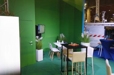 Un bus stationné de nuit devant un bâtiment illuminé, avec des passants en arrière-plan.