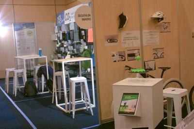 Un bus stationné de nuit devant un bâtiment illuminé, avec des passants en arrière-plan.