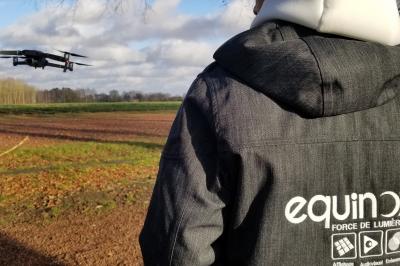 Un bus stationné de nuit devant un bâtiment illuminé, avec des passants en arrière-plan.