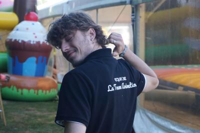 Un bus stationné de nuit devant un bâtiment illuminé, avec des passants en arrière-plan.