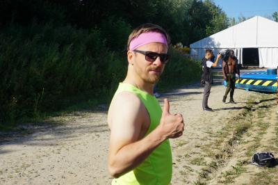 Un bus stationné de nuit devant un bâtiment illuminé, avec des passants en arrière-plan.