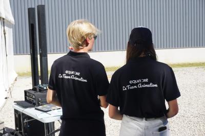 Un bus stationné de nuit devant un bâtiment illuminé, avec des passants en arrière-plan.