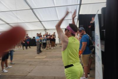 Un bus stationné de nuit devant un bâtiment illuminé, avec des passants en arrière-plan.