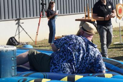 Un bus stationné de nuit devant un bâtiment illuminé, avec des passants en arrière-plan.