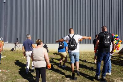 Un bus stationné de nuit devant un bâtiment illuminé, avec des passants en arrière-plan.