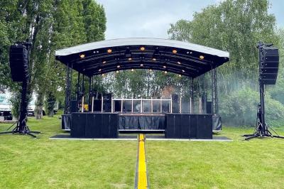 Un bus stationné de nuit devant un bâtiment illuminé, avec des passants en arrière-plan.