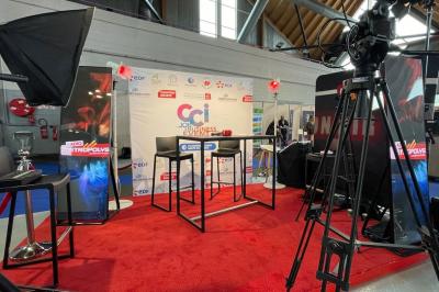 Un bus stationné de nuit devant un bâtiment illuminé, avec des passants en arrière-plan.