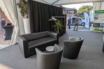 Un bus stationné de nuit devant un bâtiment illuminé, avec des passants en arrière-plan.