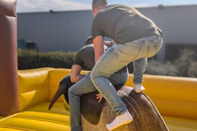 Un bus stationné de nuit devant un bâtiment illuminé, avec des passants en arrière-plan.
