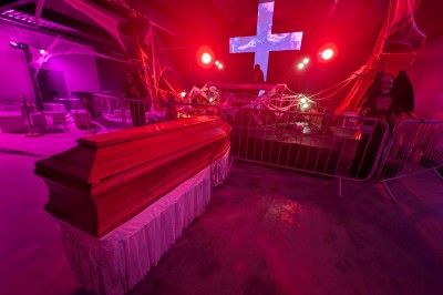 Miniature Equinoxe #197 Un bus stationné de nuit devant un bâtiment illuminé, avec des passants en arrière-plan.