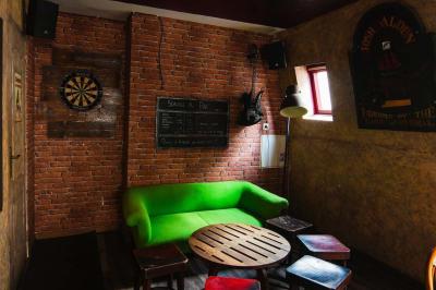 Grande table en bois massif entourée de chaises dans une pièce aux murs rouges avec poutres apparentes.