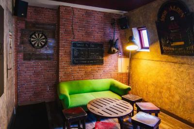 Grande table en bois massif entourée de chaises dans une pièce aux murs rouges avec poutres apparentes.
