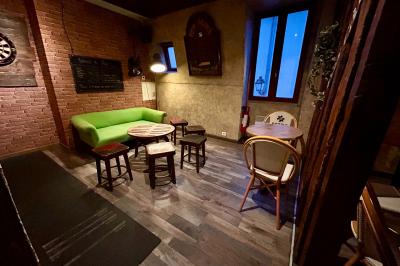 Grande table en bois massif entourée de chaises dans une pièce aux murs rouges avec poutres apparentes.
