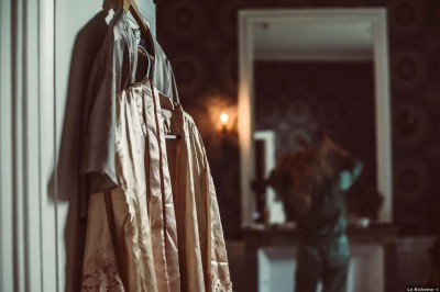 Vue aérienne d'un manoir entouré de jardins, avec des bâtiments annexes et des champs à proximité.