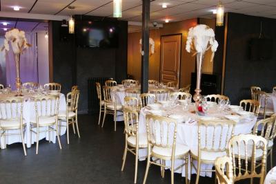 Terrasse en bois avec fauteuils, pergola à rideaux blancs, plantes en pot et mur en briques en arrière-plan.