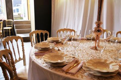 Terrasse en bois avec fauteuils, pergola à rideaux blancs, plantes en pot et mur en briques en arrière-plan.