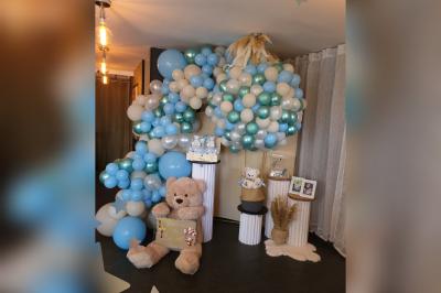 Terrasse en bois avec fauteuils, pergola à rideaux blancs, plantes en pot et mur en briques en arrière-plan.